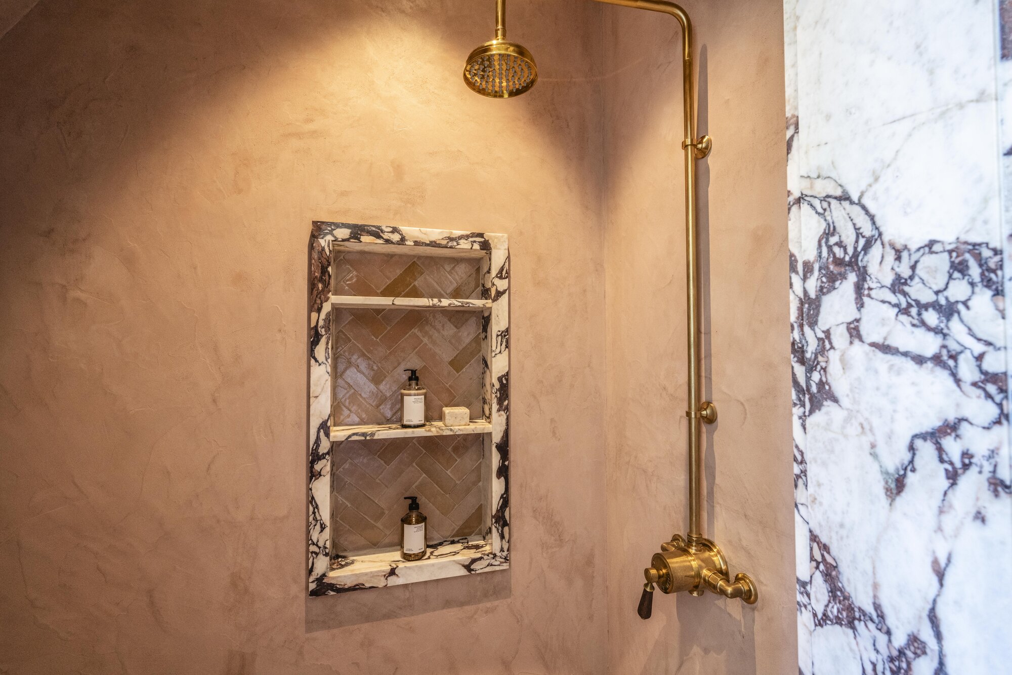Burnished lime plaster wall in raking light, polished mineral surface from the studio's project library