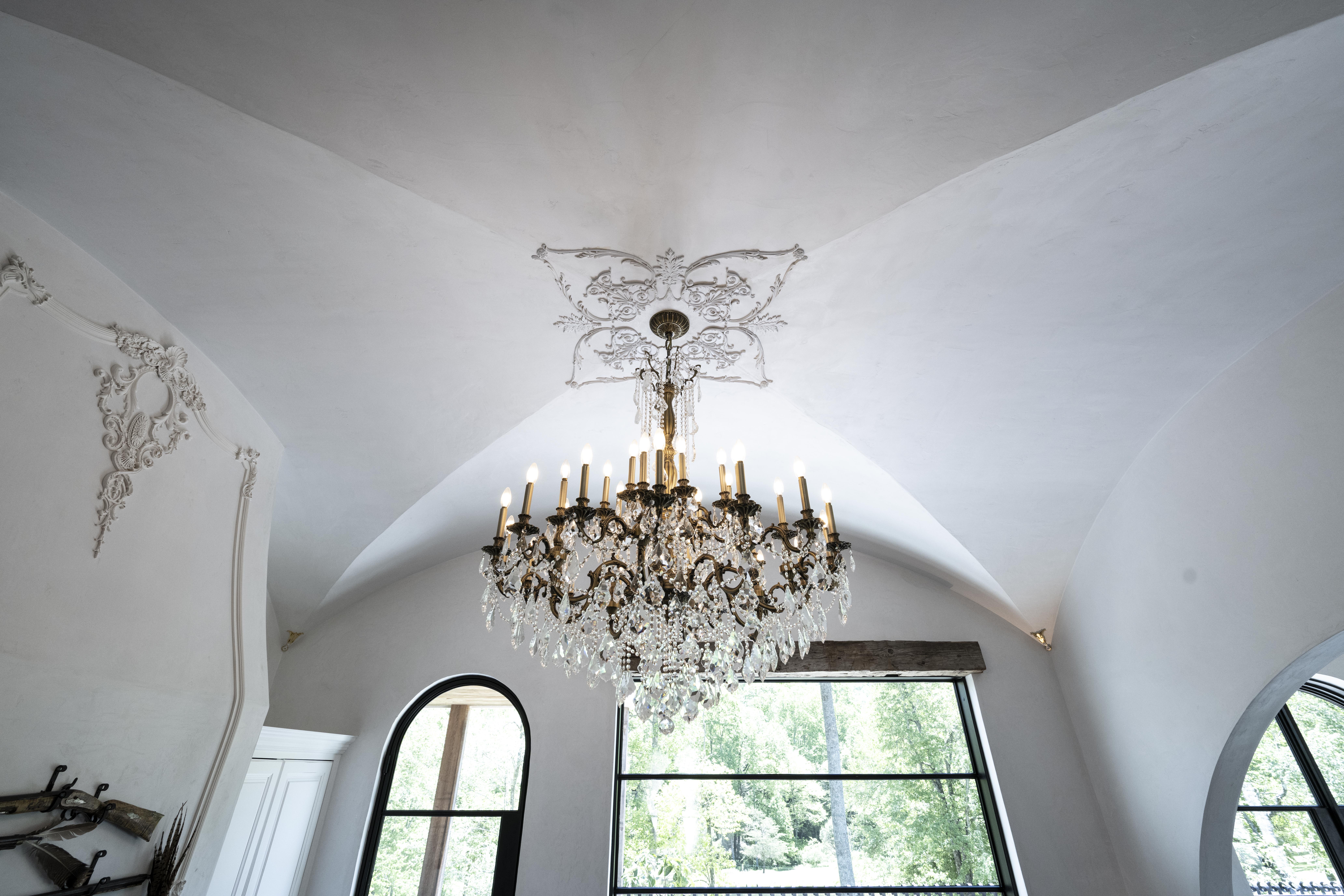 Plaster cornice and ceiling rose meeting a crystal chandelier, decorative plaster restoration